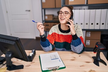 Wall Mural - Young woman ecommerce business worker talking on smartphone write on document at office