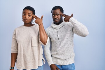 Sticker - Young african american couple standing over blue background together shooting and killing oneself pointing hand and fingers to head like gun, suicide gesture.