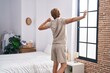 © Krakenimages.com - Young man waking up stretching arms at bedroom