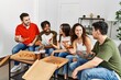 © Krakenimages.com - Group of young friends smiling happy eating italian pizza sitting on the sofa at home.