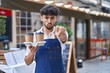 © Krakenimages.com - Arab man with beard wearing waiter apron at restaurant terrace pointing with finger to the camera and to you, confident gesture looking serious