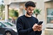 © Krakenimages.com - Young arab man smiling confident using smartphone at street
