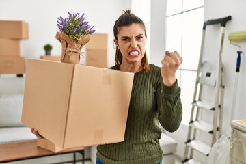 Sticker - Young hispanic woman holding cardboard box at moving annoyed and frustrated shouting with anger, yelling crazy with anger and hand raised