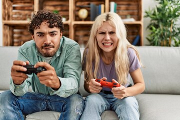 Poster - Young couple screaming and playing video game at home.