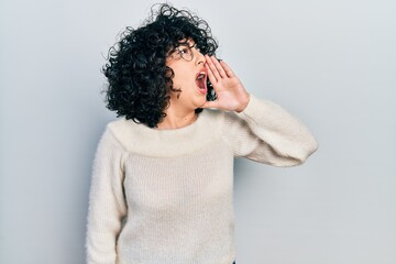 Sticker - Young middle east woman wearing casual white tshirt shouting and screaming loud to side with hand on mouth. communication concept.