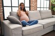 © Krakenimages.com - Young pregnant woman having conversation speaking on the smartphone smiling happy and positive, thumb up doing excellent and approval sign