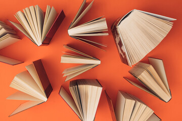 Wall Mural - Creative pattern made of books on bright orange background. Education and  knowledge concept. Flat lay.
