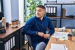 © Krakenimages.com - Young hispanic man business worker smiling confident sitting on des at office