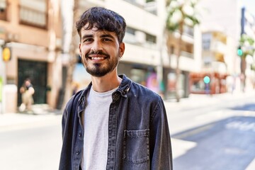 Poster - Young hispanic man smiling happy standing at the city.