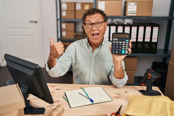 Sticker - Senior man working at small business ecommerce with calculator pointing thumb up to the side smiling happy with open mouth