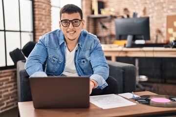 Sticker - Young man musician using laptop sitting on sofa at music studio