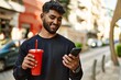 © Krakenimages.com - Young arab man using smartphone drinking soda at street