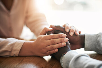 Closeup of hands of couple holding in loving support of care and comfort after grieving loss. Kind friends express sympathy and trust for each other in sweet and caring gesture together