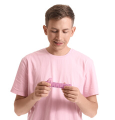 Wall Mural - Young man holding container with pills on white background