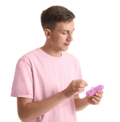 Wall Mural - Young man holding container with pills on white background