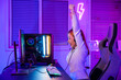 Leinwandbild Motiv Winning Victory. Asian gamer playing online video game excited on desktop computer PC colorful neon LED lights, young woman in gaming headphones using computer she happy successful, E-Sport concept