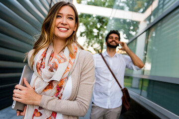 Happy businessman and woman with digital devices outdoors. Business people happiness concept