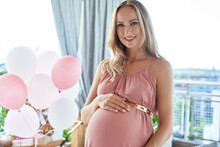 Smiling Pregnant Woman Wearing Pink Dress At Baby Shower