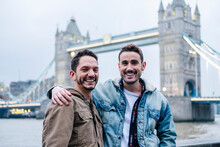 London, United Kingdom, A Couple Of Guysstanding In Front Of Tower Bridge With Arms Around
