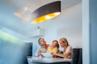 © Westend61 - Family controlling ceiling lamp with tablet PC in Smart Home