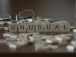 Unusual word or concept represented by wooden letter tiles on a wooden table with glasses and a book