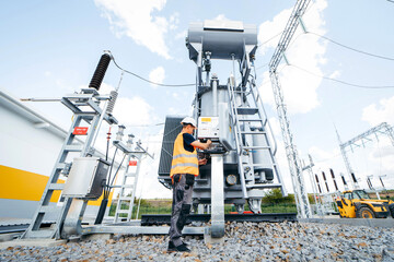 Wall Mural - Adult electrical engineer inspect the electrical systems at the equipment control cabinet. Installation of modern electrical station