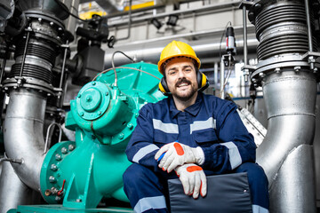 Portrait of factory worker supervisor standing by gas generator in energy heating plant.