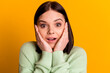 © Tetiana - Photo of young cheerful girl hands touch cheeks amazed shock reaction isolated over yellow color background