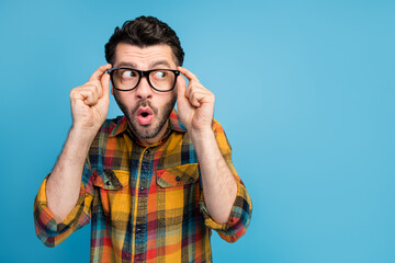 Sticker - Photo of impressed handsome thoughtful man dressed checkered shirt look empty space touch glasses isolated on blue color background