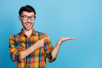 Sticker - Photo of impressed bunet guy hold index empty space wear eyewear plaid shirt isolated on blue color background