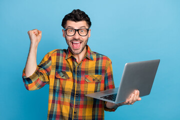 Poster - Photo of hooray brunet guy hold laptop yell wear eyewear plaid shirt isolated on blue color background