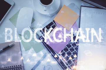 Poster - Blockchain theme hologram drawings over computer on the desktop background. Top view. Multi exposure. Concept of cryptoeconomy.