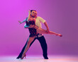 Leinwandbild Motiv Young man and woman, ballroom dancers in motion isolated on purple background. Concept of art, beauty, music, style.
