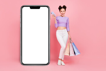 Full length body size view of attractive cheery girl using gadget buying things web app isolated over pink pastel color background