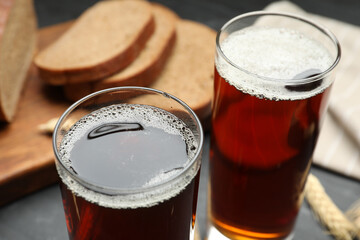 Glasses of delicious kvass on black table, closeup