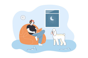 Wall Mural - man in headphones sitting with laptop in bean bag chair. person and dog spending evening time at hom