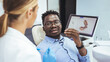 © Dragana Gordic - Young black man holding cheek in chair at dentist, having toothache. Young good looking man having dental treatment at dentist's office.