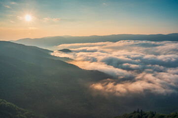 Wall Mural - amazing aerial view of beautiful low clouds creeping on the tree-covered mountain slopes, the rhodop
