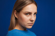 Young white serious woman wearing sweater looking at camera