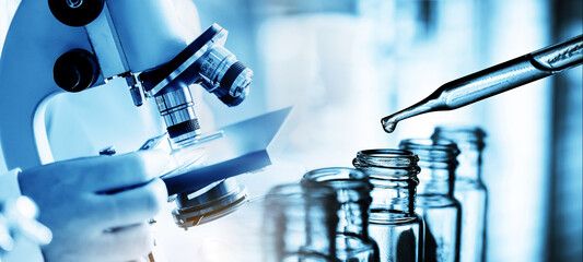 Wall Mural - hand of scientist holding flask with lab glassware in chemical laboratory background, science labora
