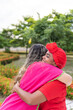 © Hector Pertuz - Two Latin women embrace each other in city park