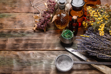 Wall Mural - Herbal medicine concept background. Dry natural ingredients and remedy bottle on the wooden table flat lay background with copy space.