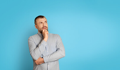 Poster - Thoughtful Middle Aged Man Thinking Touching Chin On Blue Background