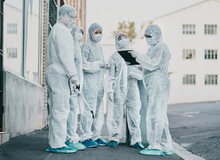 Covid, Pandemic And Healthcare Team Wearing Protective Ppe To Prevent Virus Spread At A Quarantine Site. First Responders Wearing Hazmat Suits While Discussing Plan For Cleaning And Disinfecting