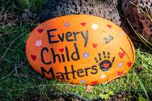 A Hand-painted Rock That Says "Every Child Matters" On The Ground Against A Tree. It Refers To The Remains Of Childrens Bodies Believed To Be Buried At Former Residential Schools Across Canada.
