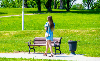 Wall Mural - Girl walks in the city summer Park
