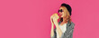 Portrait of happy smiling young woman with big burger fast food on pink background