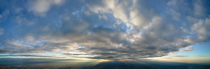 Aerial view at high altitude of dense puffy cumulus clouds flying in evening