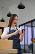 © bongkarn - Excited and cheerful young Asian female business startup checking her online orders