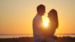 © lenblr - Happy couple silhouettes stand showing pure love to each other in back lit. Wife and husband enjoy being together and stand on meadow at orange back sunset side view